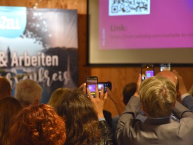 Die Gäste der ZaC-Konferenz machen Fotos von der spannenden Präsentation von Dr. Andreas Kohne.